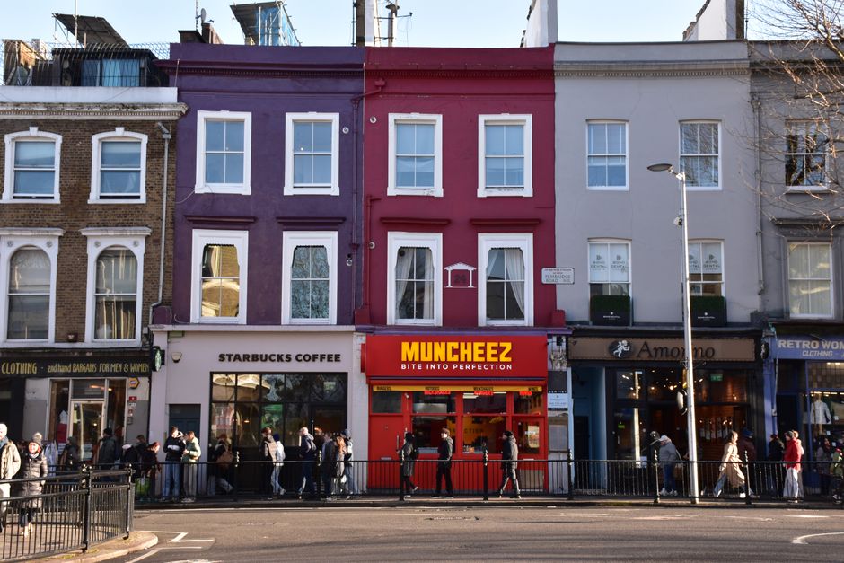 A row of commercial buildings on Jamaica Road in Bermondsey, London, featuring a mix of retail shops and cafes. The ground level includes a Starbucks Coffee store with large glass windows, and a brigh